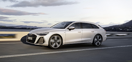 Der Audi A6 Avant e-hybrid in silber metallic vor einem modernen Haus