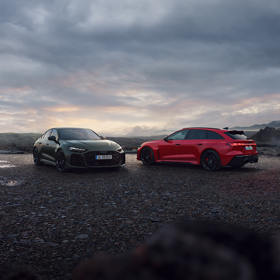 Ein blauer Audi Q6 e-tron in der Dreiviertelansicht von vorne bei der Fahrt auf einer Stra&szlig;e