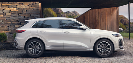 Ein wei&szlig;er Audi parkend in der Seitenansicht vor einem Geb&auml;ude