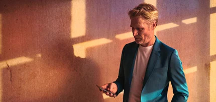 Ein Mann der auf sein Handy schaut 